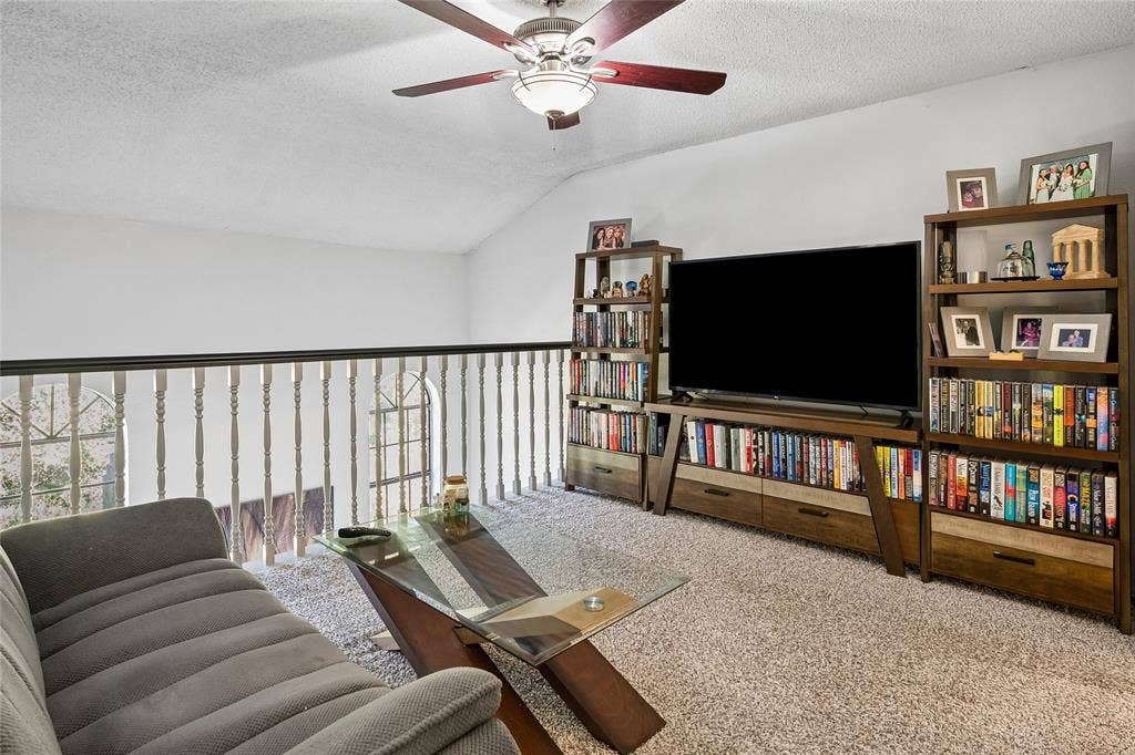 Vaulted ceiling, ceiling fan with light fixture, and balustrade railing