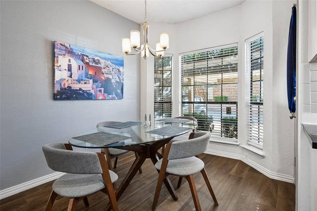 Bay window featuring grid-paneled windows, wood-finish flooring, and a multi-arm metallic chandelier