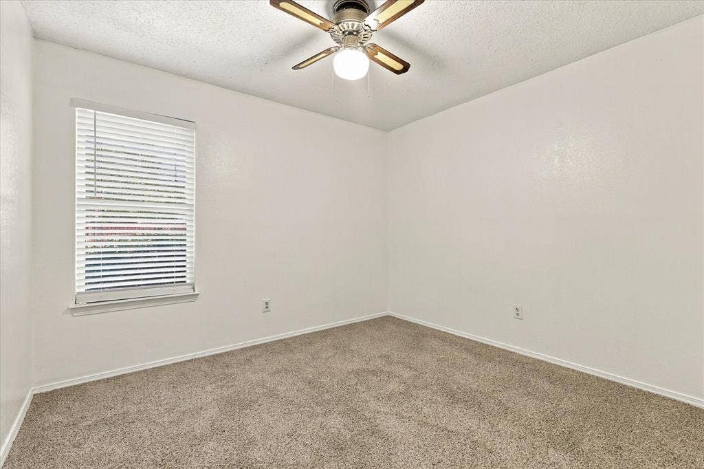 844 Woodrock Drive, Dallas, TX 75217 Window with blinds, ceiling fan with integrated lighting, and neutral carpet flooring