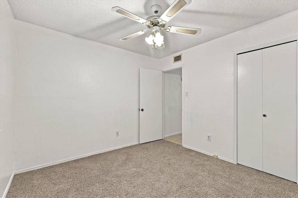 844 Woodrock Drive, Dallas, TX 75217 Neutral wall finishes, textured ceiling, ceiling fan with integrated lighting, and carpeted flooring