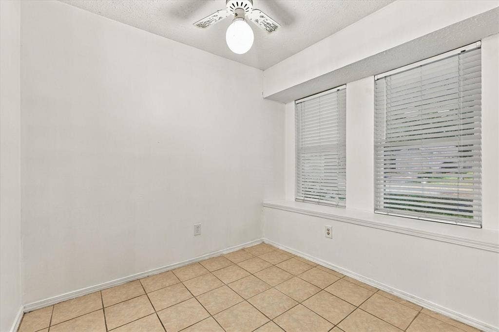 844 Woodrock Drive, Dallas, TX 75217 White walls with a textured ceiling, tile flooring, and a ceiling fan with integrated lighting