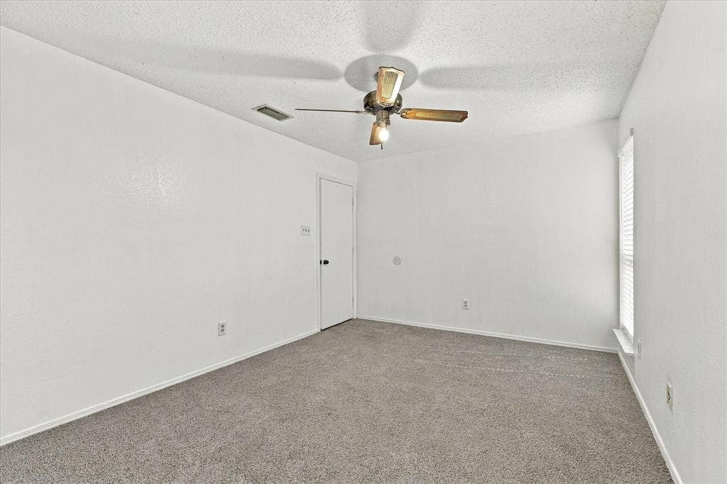 844 Woodrock Drive, Dallas, TX 75217 Neutral white walls with textured finish, carpeted flooring, window with blinds, and a ceiling fan with integrated lighting