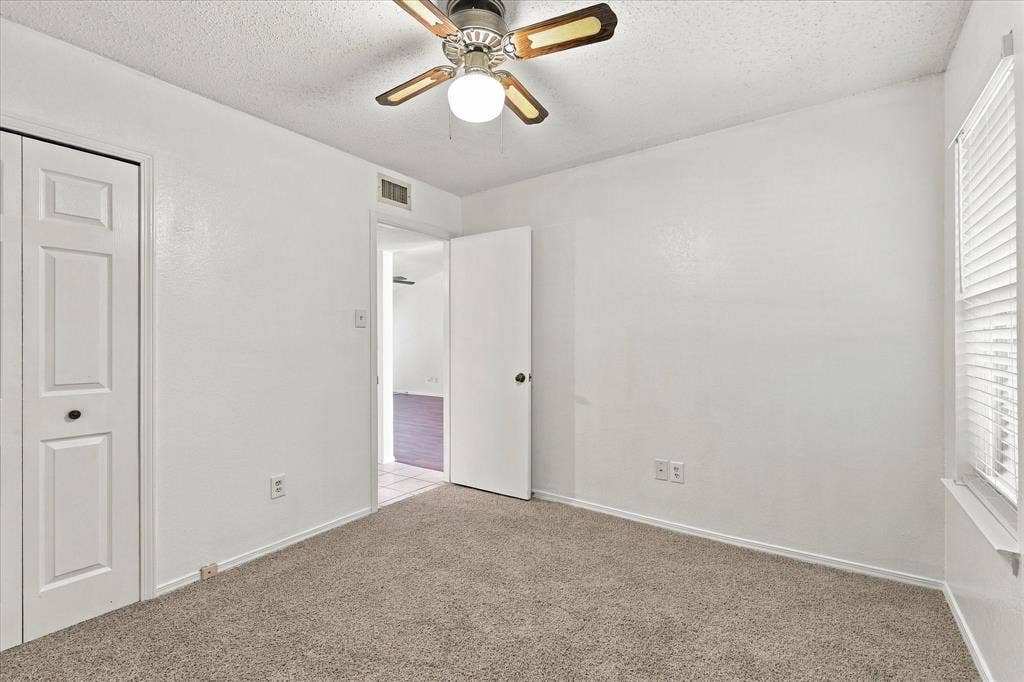 844 Woodrock Drive, Dallas, TX 75217 Neutral-toned carpeting, ceiling fan with light fixture, and window with blinds