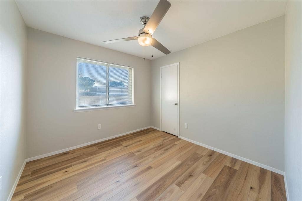 802 Birchwood Drive, Garland, TX 75043 Wood-finish flooring, ceiling fan with integrated lighting, and a window with blinds