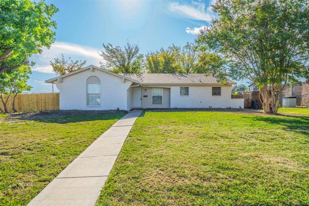 802 Birchwood Drive, Garland, TX 75043 White-painted brick exterior with a grey roof
