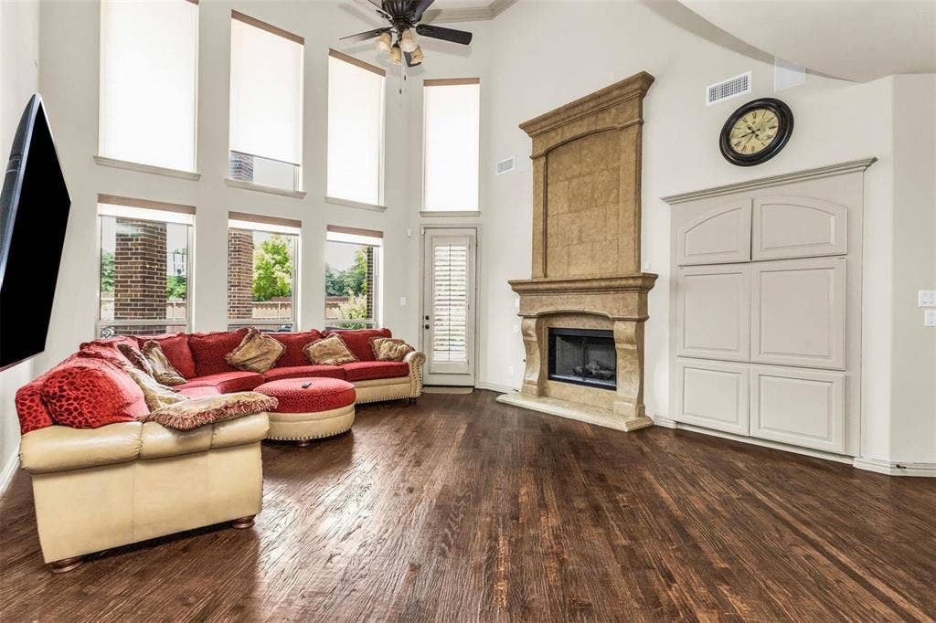 1838 Olney Drive, Allen, TX 75013 Vaulted ceilings, wood-finish flooring, a stone-clad fireplace, and built-in cabinetry