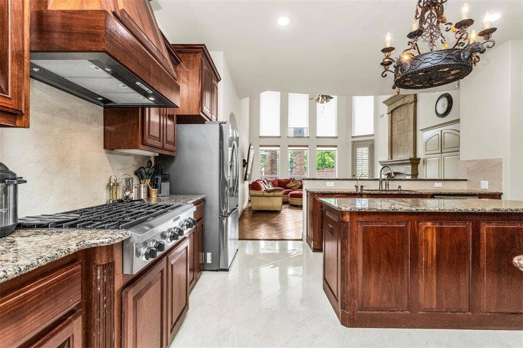 1838 Olney Drive, Allen, TX 75013 Gourmet kitchen with stainless steel appliances, granite countertops, wood cabinetry, and a large central island