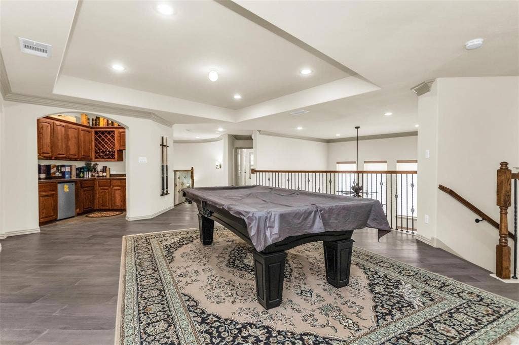 1838 Olney Drive, Allen, TX 75013 Upper-level recreation area featuring wood-finish flooring and a built-in wet bar with wood cabinetry and an undercounter refrigerator