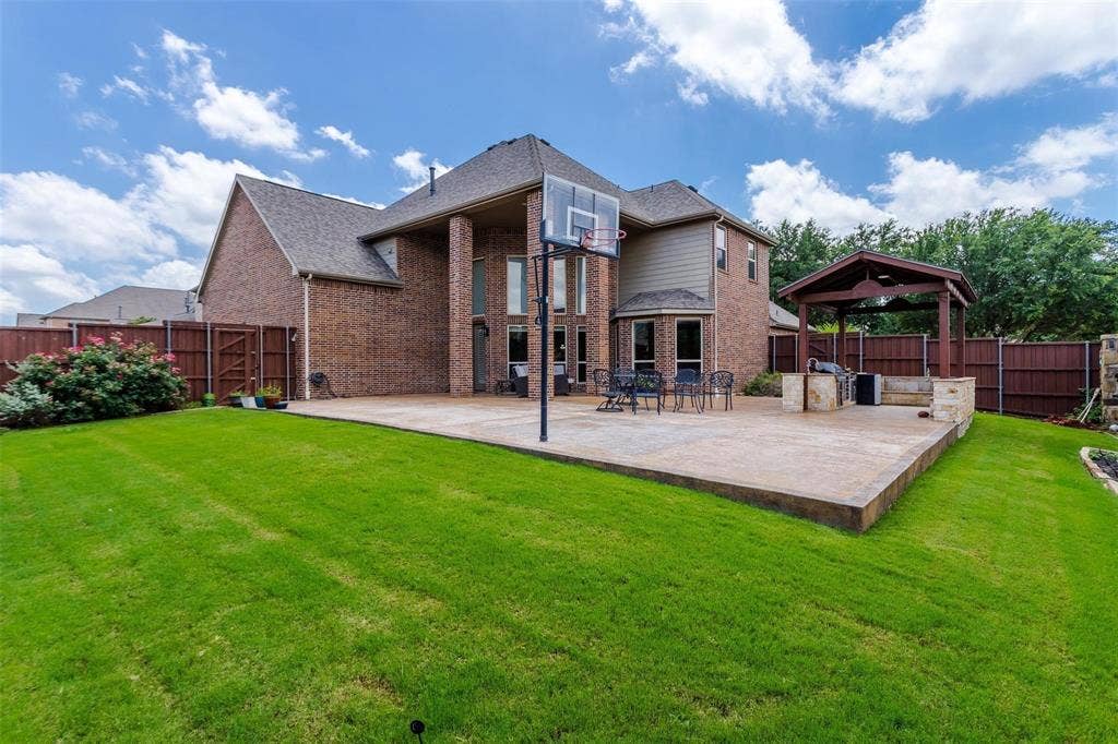 1838 Olney Drive, Allen, TX 75013 Brick exterior with multiple windows, leading to an expansive concrete patio