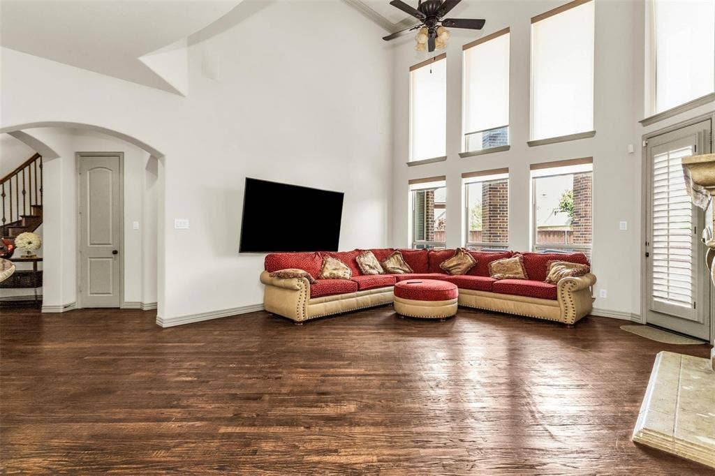 1838 Olney Drive, Allen, TX 75013 Two-story living area with wood-finish flooring, soaring ceilings, and multiple windows with roller shades