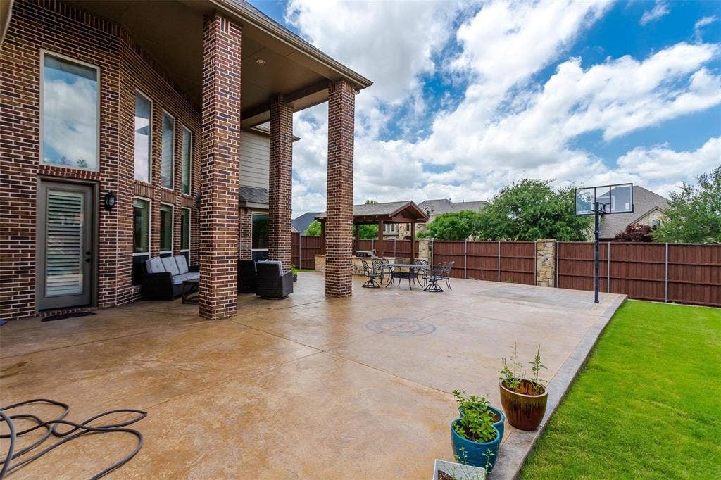 1838 Olney Drive, Allen, TX 75013 Expansive concrete patio with a covered outdoor area, brick columns, and a basketball hoop