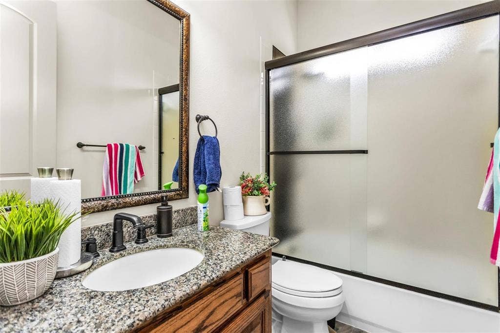 1838 Olney Drive, Allen, TX 75013 Vanity with granite-style countertop, oval sink, and dark bronze-finish faucet