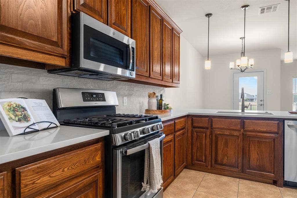 Kitchen featuring built-in microwave, gas range, and bright natural light
