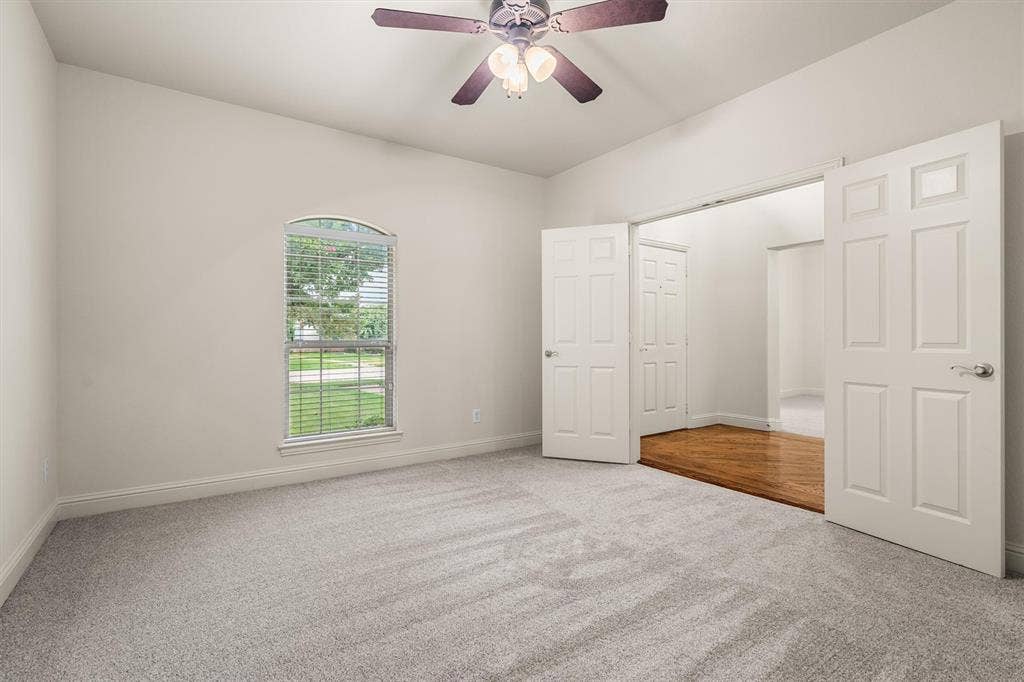 Bright flex room with ceiling fan and French doors — ideal home office or study