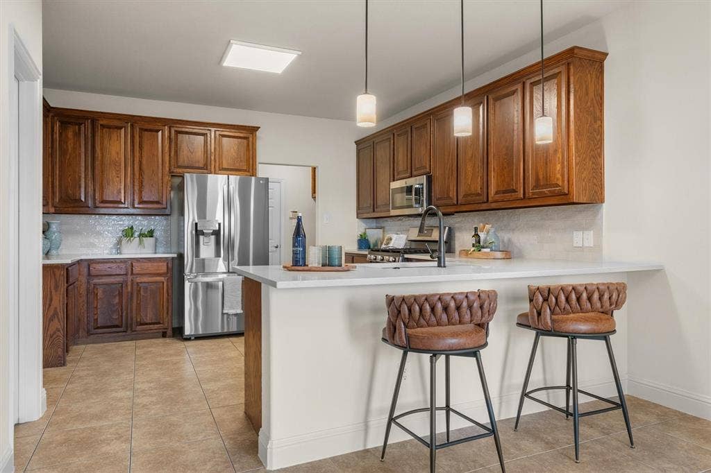 Kitchen view highlighting bar-top seating and pendant lighting