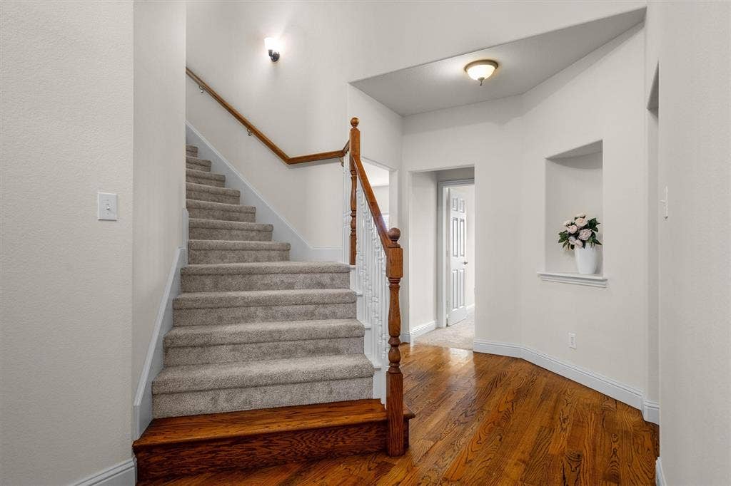 Elegant entry hallway with staircase and rich wood flooring