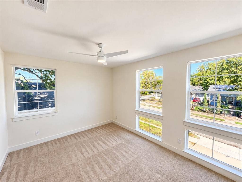 Neutral wall finishes, recessed lighting, ceiling fan, multiple windows, and carpeted flooring