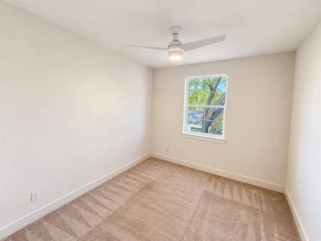 Neutral-toned walls, carpeted flooring, and a single window