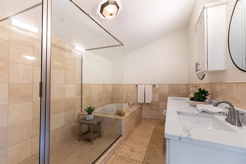 The ensuite bathroom has an oversized shower. The tub wall is an exterior wall and the addition of a clerestory window would bring glorious southern light into the space.