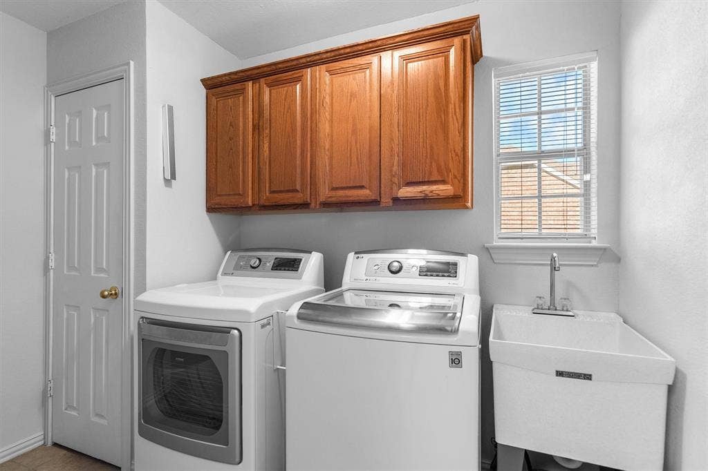 large laundry room with a sink and cabintry