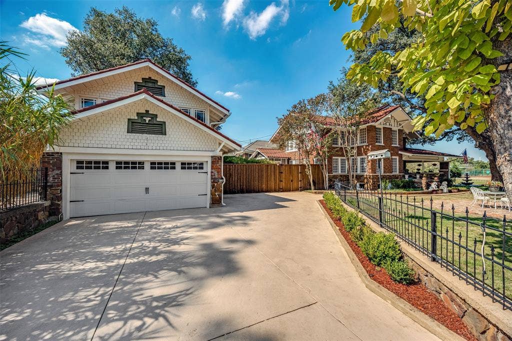 320 E 5th Street, Dallas, TX 75203 Garage featuring an epoxy floor, built-in shelving, laundry appliances, a water heater, and an EV charging station