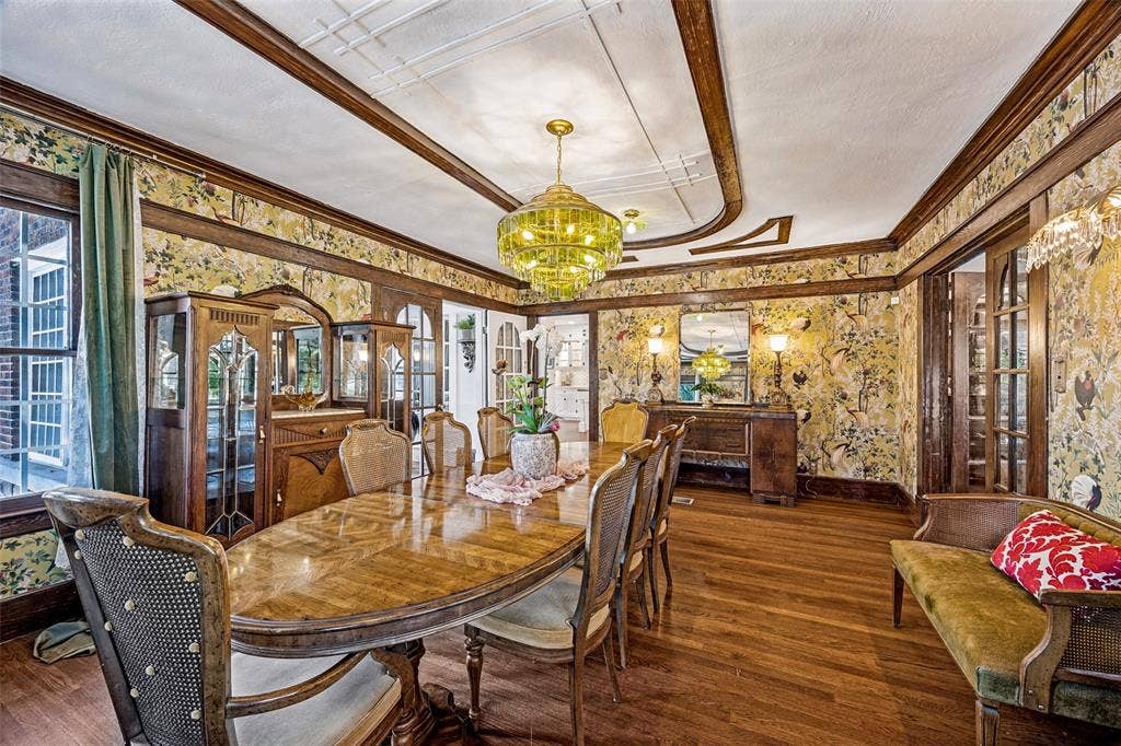 320 E 5th Street, Dallas, TX 75203 Hardwood flooring, decorative ceiling trim, ornate chandelier, patterned wall coverings, and built-in wood cabinetry
