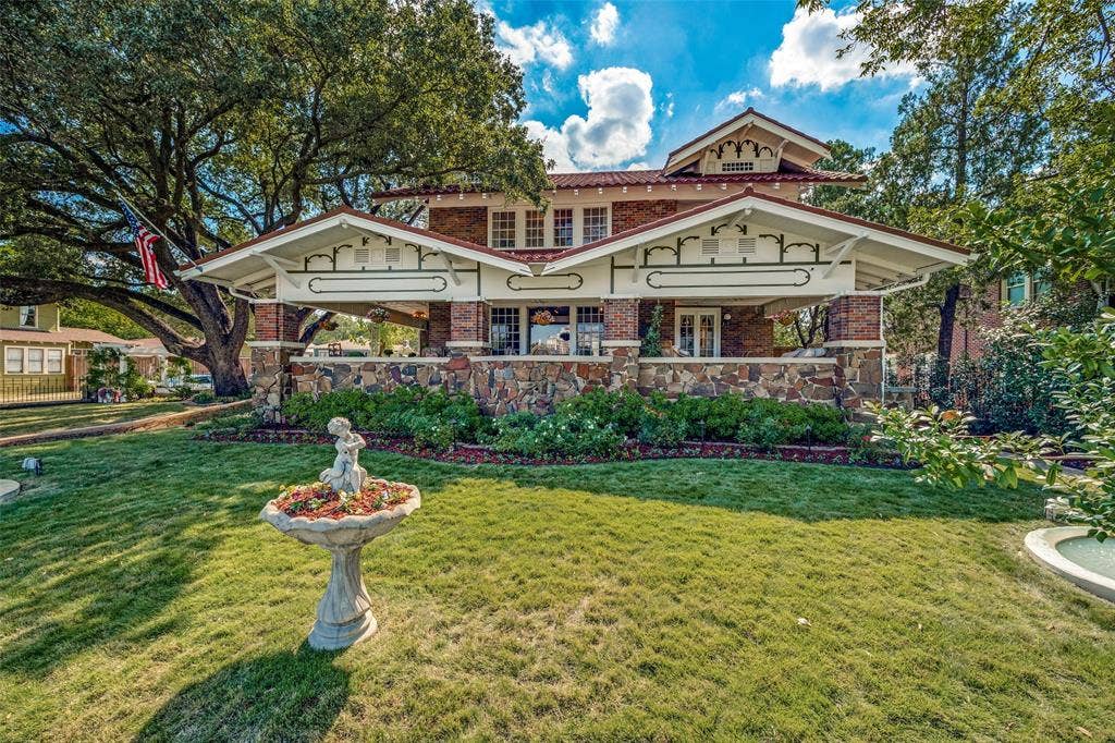 320 E 5th Street, Dallas, TX 75203 Craftsman-style exterior with brick and stone accents, covered porch, multiple gables, and a mature tree canopy