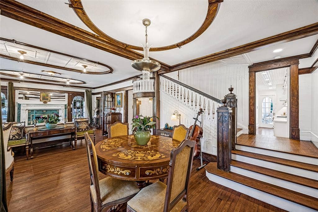 320 E 5th Street, Dallas, TX 75203 Hardwood flooring, ornate ceiling details, built-in fireplace, detailed wood staircase, and custom millwork throughout