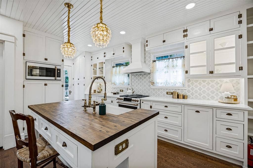 320 E 5th Street, Dallas, TX 75203 White cabinetry with glass-front accents, dark wood-finish flooring, a kitchen island featuring a wood-finish countertop, and a white farmhouse sink