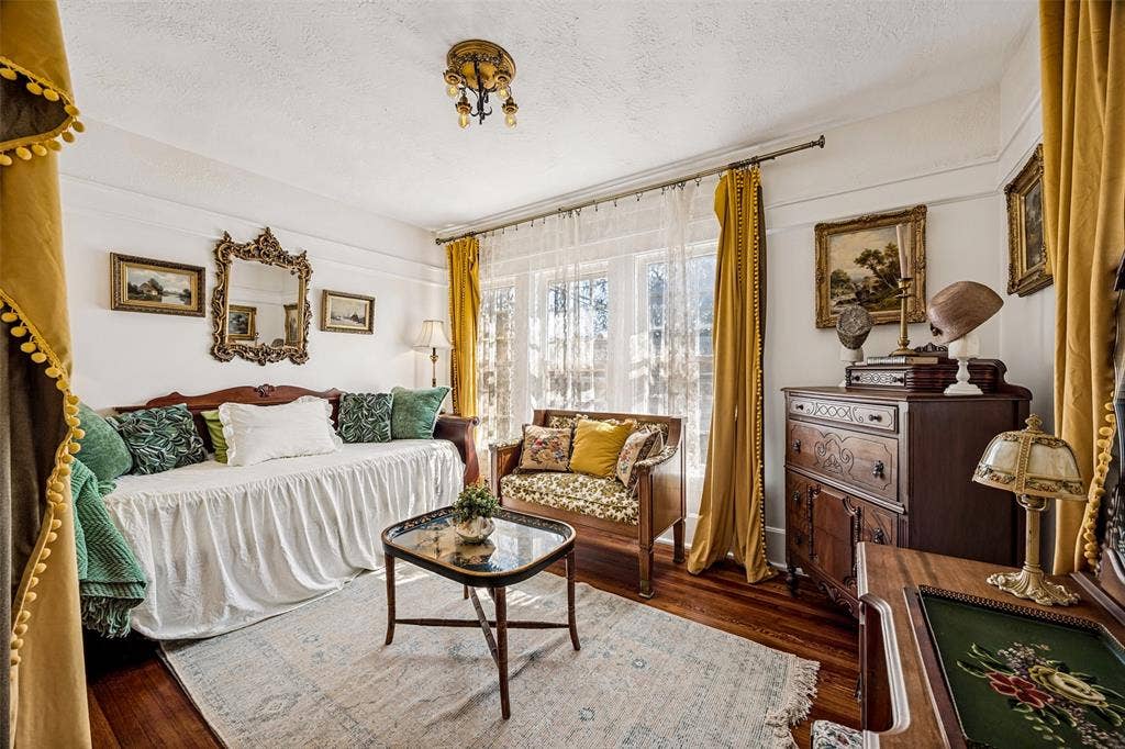 320 E 5th Street, Dallas, TX 75203 Hardwood flooring, ornate ceiling light fixture, white walls, large window with sheer and solid drapes, decorative wall mirror