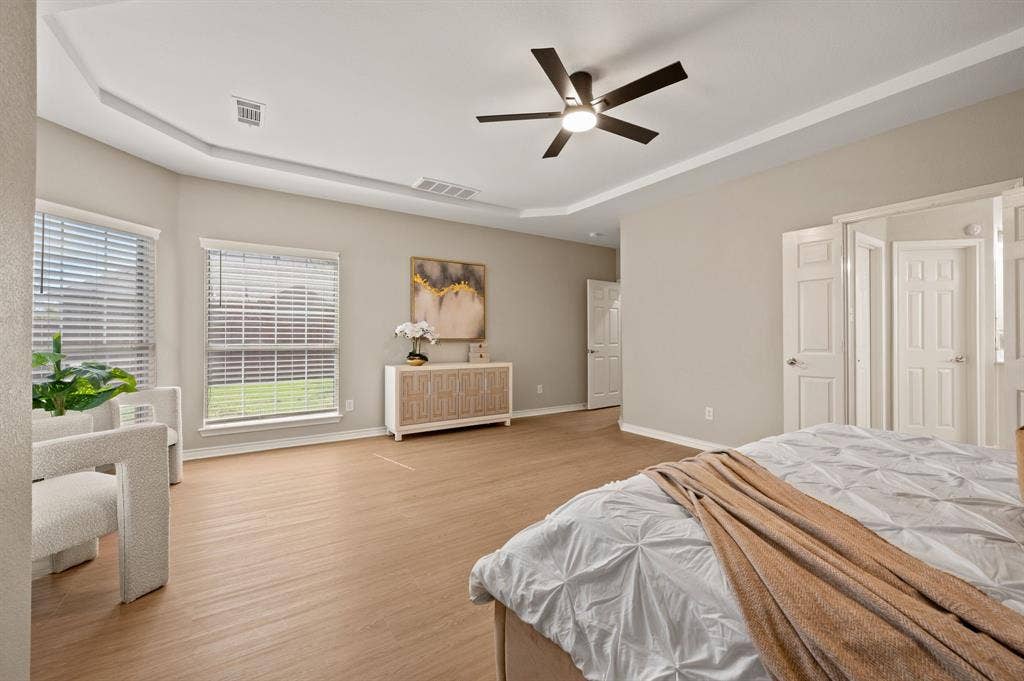 Room to relax! This spacious primary retreat features a tray ceiling, sunny windows & plenty of space for your favorite furnishings.