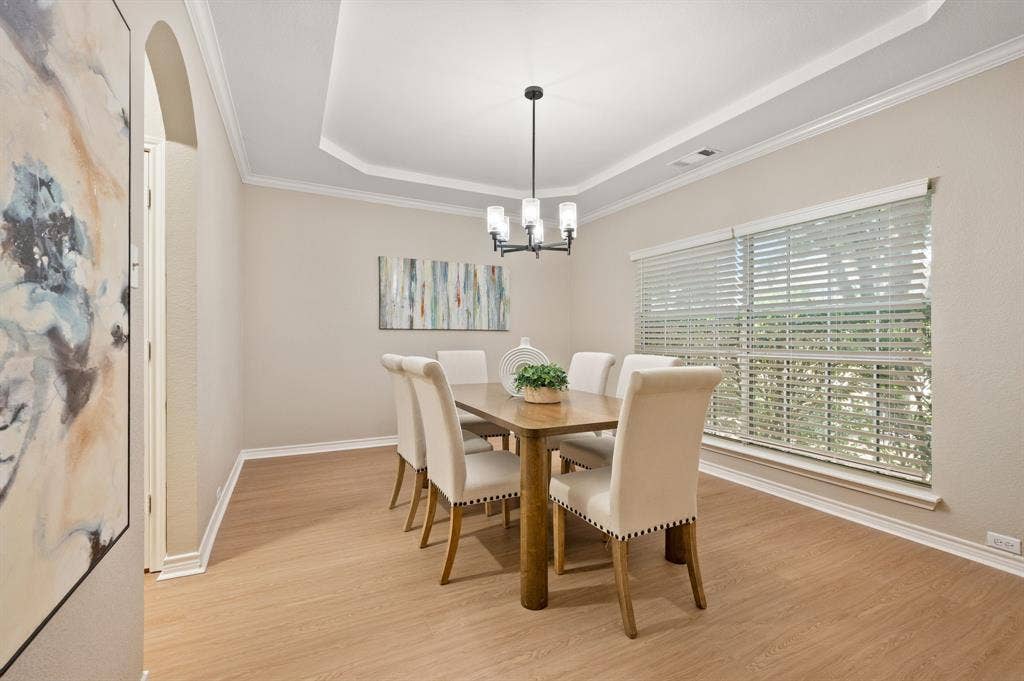 Gather in style in the elegant formal dining room, featuring a tray ceiling, chandelier & generous windows for beautiful natural light.