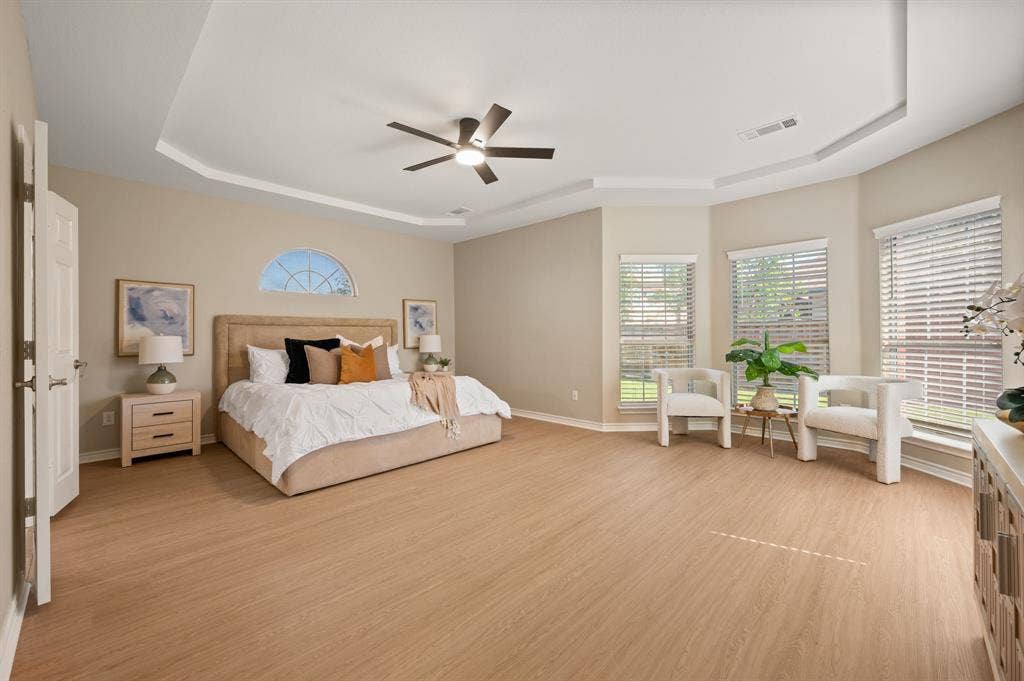 Unwind in this spacious bedroom retreat, featuring a tray ceiling, ceiling fan & a sunny bay-window sitting area.
