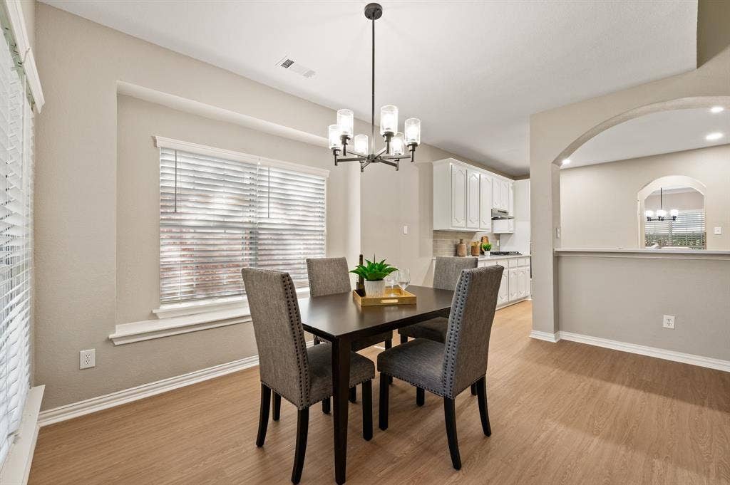 Start your mornings in the bright breakfast area, conveniently positioned beside the kitchen with generous windows & a stylish chandelier.
