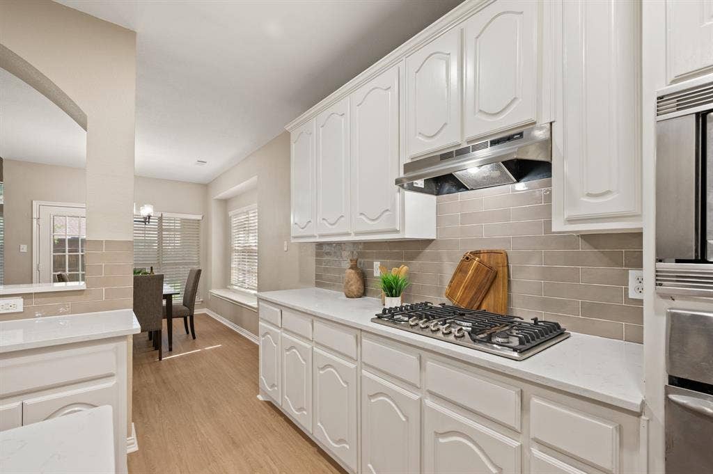 Bring your favorite recipes to life with a gas cooktop, stainless vent hood, tile backsplash & abundant cabinet storage.