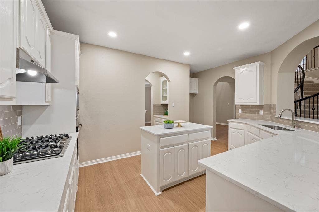 Cooking is a pleasure in this spacious kitchen, featuring freshly painted white cabinetry, new quartz countertops, an updated backsplash and a new gas cooktop!
