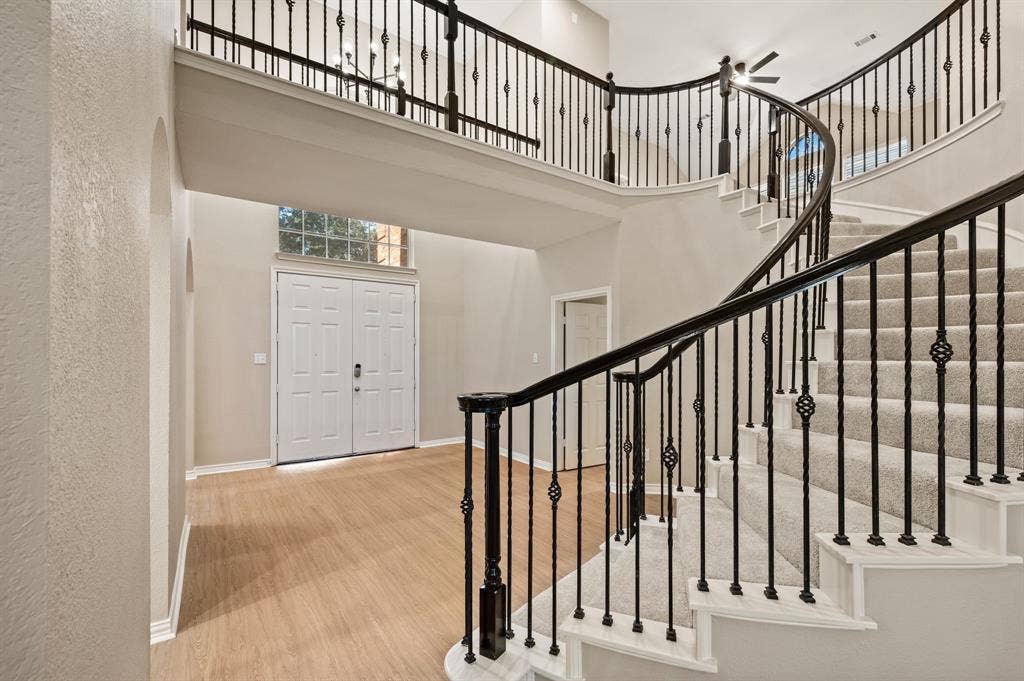 Make a grand entrance! Soaring ceilings, a sweeping curved staircase & decorative iron balusters set the stage for this inviting home.