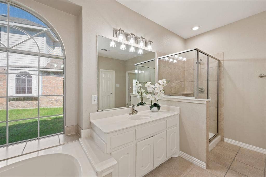 A bright vanity, generous mirror & separate tiled shower make this inviting primary bath a comfortable place to start your day.