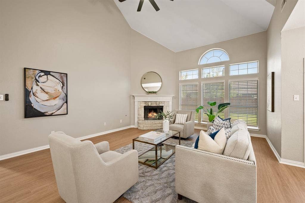 A cozy fireplace & a stunning wall of windows make this spacious living room an inviting spot to relax or entertain.