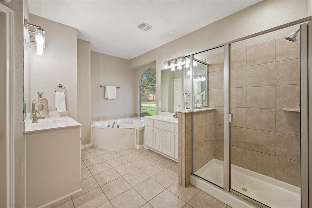 Unwind in the primary bath with a relaxing soaking tub, separate glass-enclosed shower & two vanity areas.
