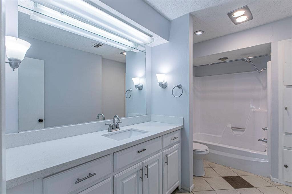 9326 Emberglow Lane, Dallas, TX 75243 Bathroom1 featuring shower / washtub combination, light tile patterned floors, vanity, a textured ceiling, and recessed lighting