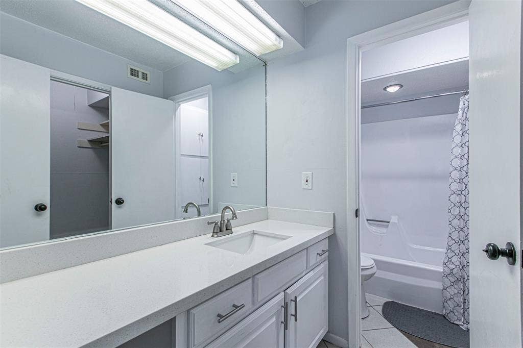 9326 Emberglow Lane, Dallas, TX 75243 Bathroom2 with vanity, shower / bath combination with curtain, and light tile patterned floors