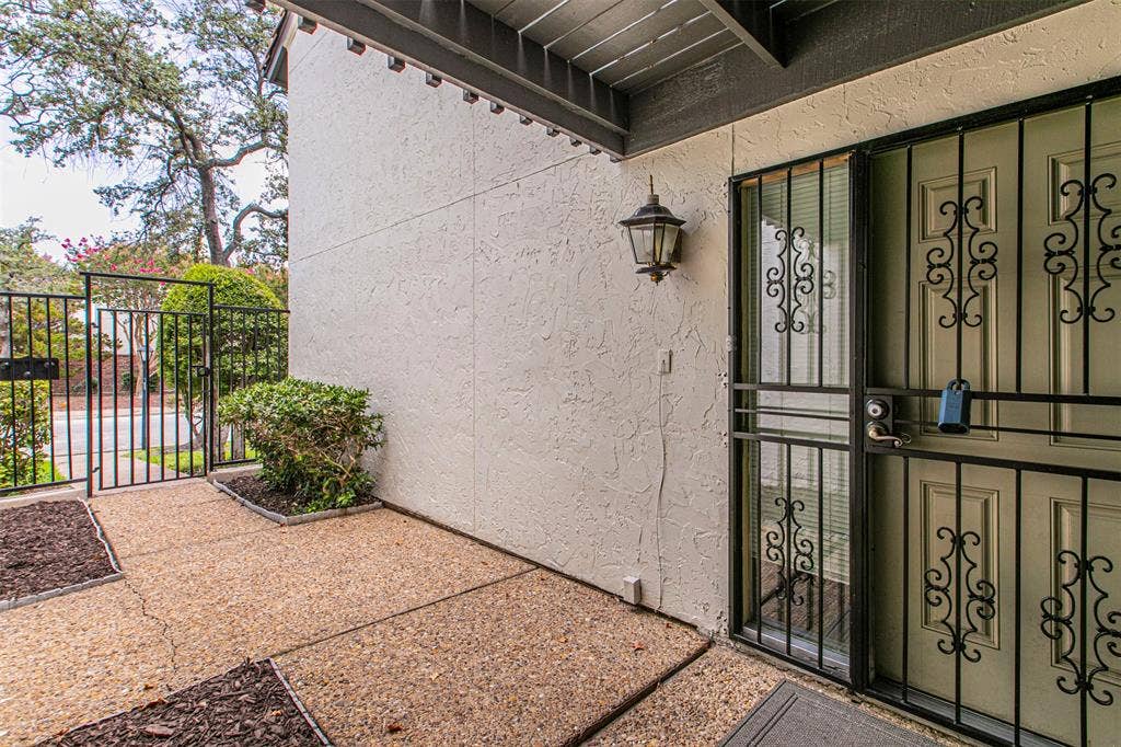 9326 Emberglow Lane, Dallas, TX 75243 Property entrance featuring a gate and stucco siding