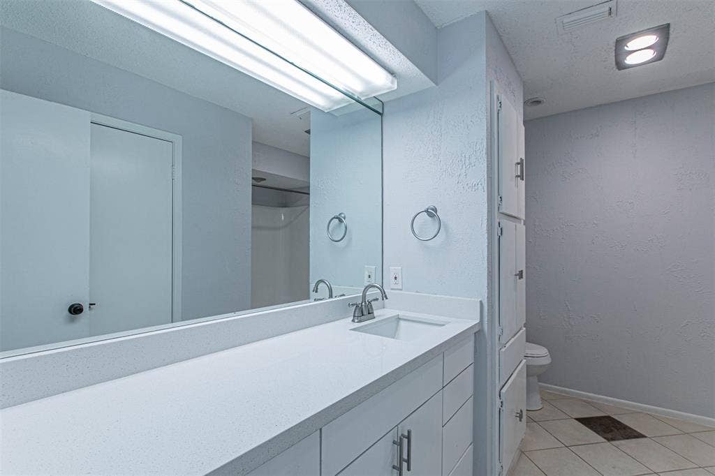 9326 Emberglow Lane, Dallas, TX 75243 Bathroom3 featuring light tile patterned floors, vanity, and a textured wall