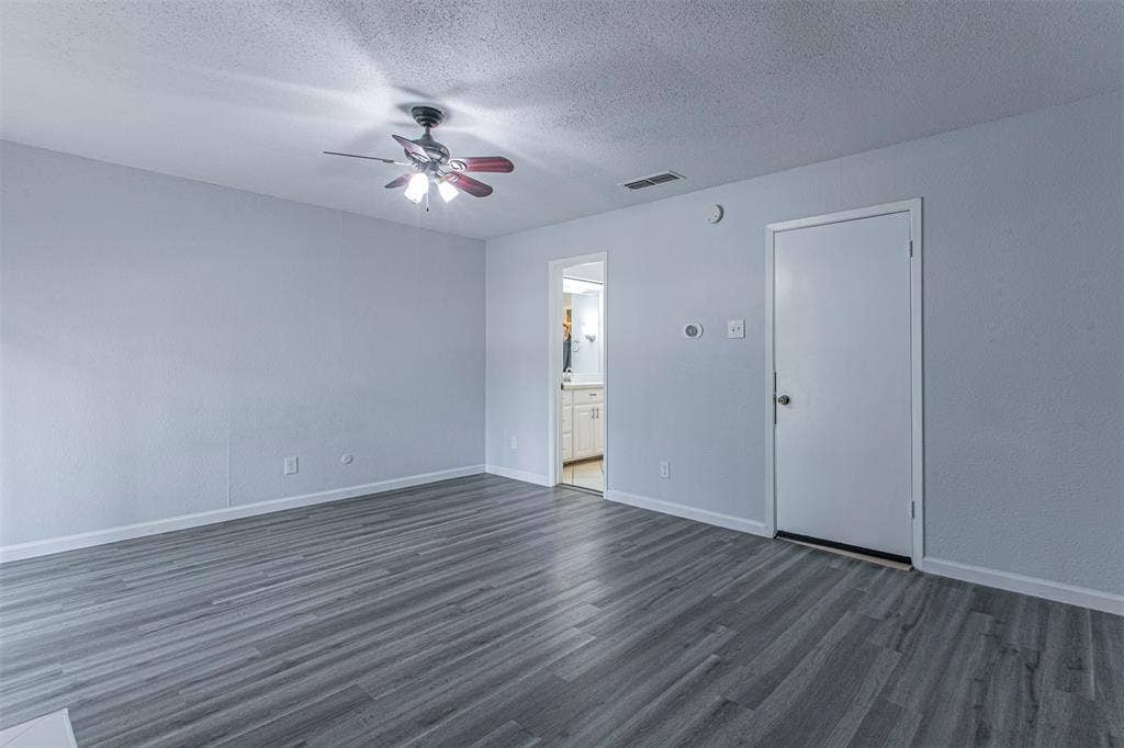 9326 Emberglow Lane, Dallas, TX 75243 bedroom 3with dark wood-style floors, a textured ceiling, a ceiling fan, and ensuite bath