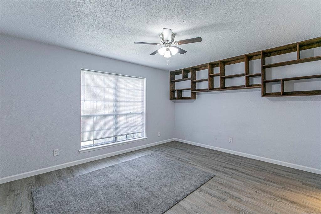9326 Emberglow Lane, Dallas, TX 75243 Bedroom 1 unfurnished featuring light wood-style floors and a ceiling fan
