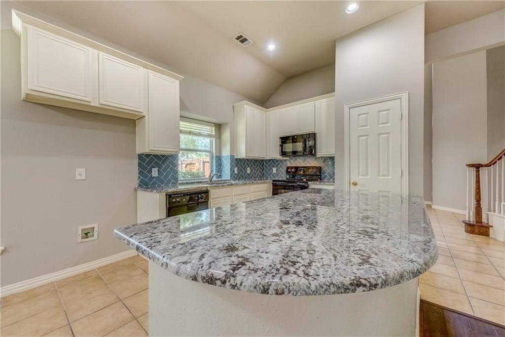 2300 Reston Drive, McKinney, TX 75072 Kitchen with a center island, white cabinetry, black appliances, and tasteful backsplash