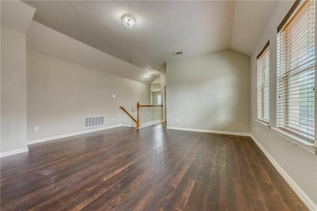 2300 Reston Drive, McKinney, TX 75072 Unfurnished room with dark hardwood / wood-style flooring and vaulted ceiling