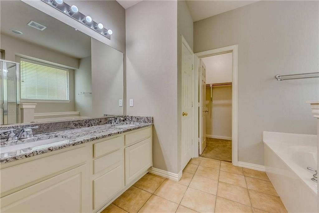 2300 Reston Drive, McKinney, TX 75072 Bathroom with dual sinks, large vanity, tile floors, and plus walk in shower