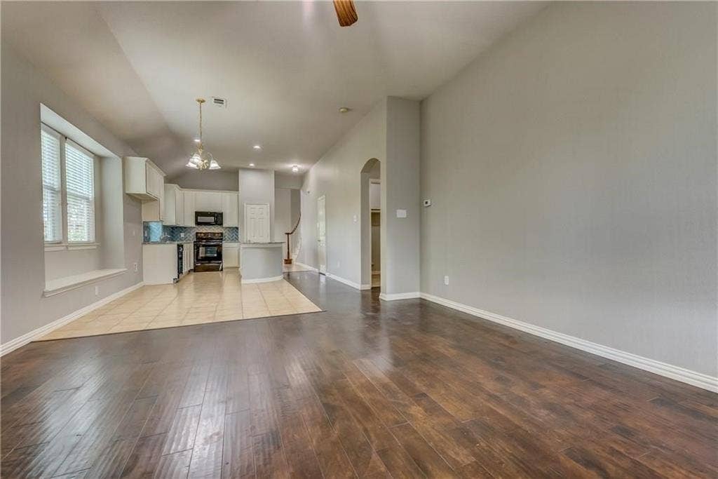 2300 Reston Drive, McKinney, TX 75072 Unfurnished living room featuring light tile floors and an inviting chandelier